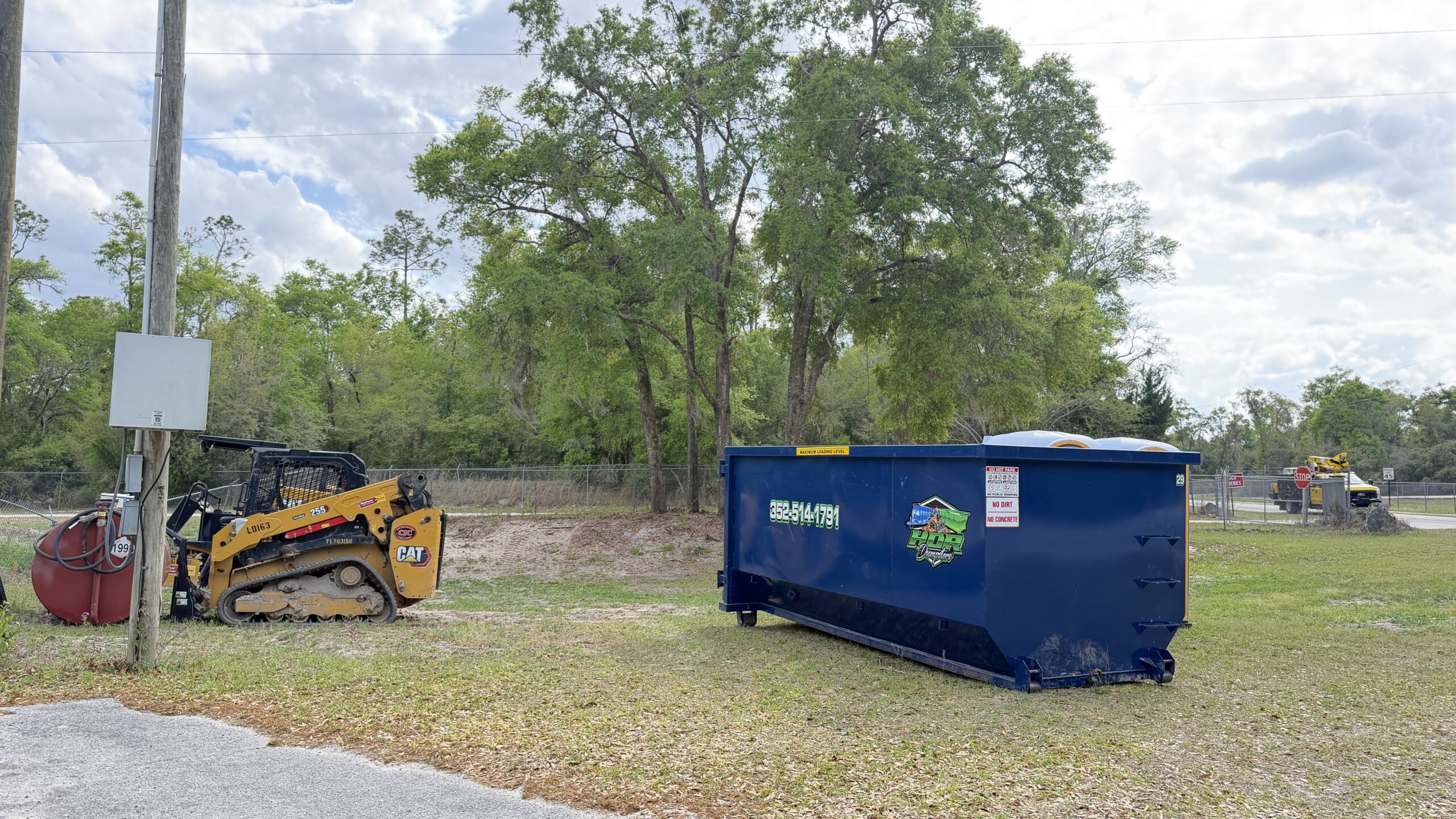 20-yard HDR Dumpster on a job site being loaded by a skid steer